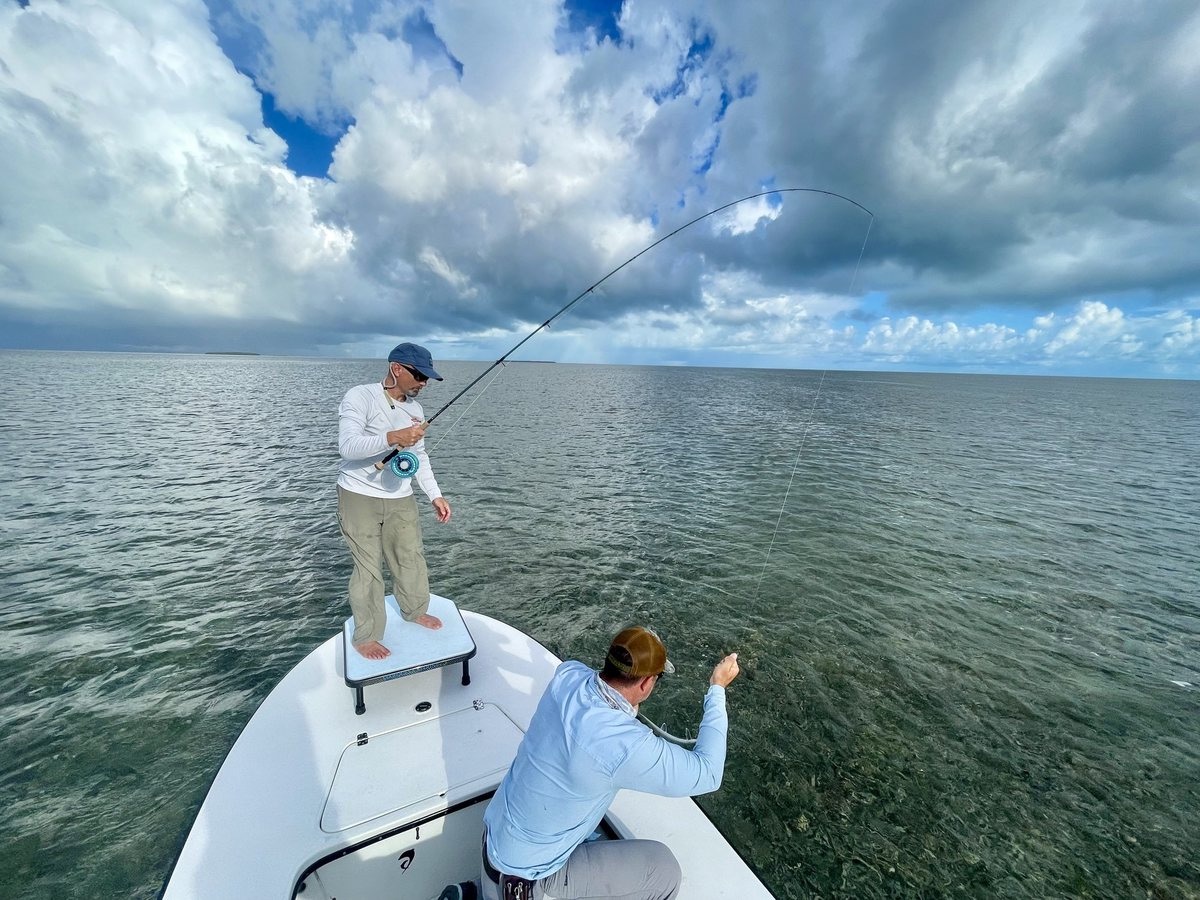Founder Rich Volpe on the bow of a skiff, Director Nathaniel Linville stripping line beside him, on the flats near Key West
